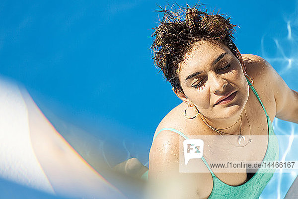 Porträt einer jungen Frau  die sich im Schwimmbad entspannt