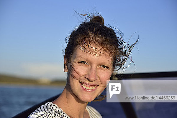 Porträt einer lächelnden jungen Frau auf einem Boot auf dem Meer