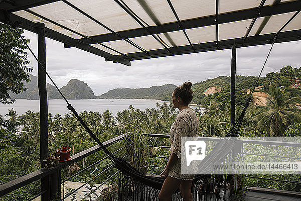 Philippinen  Palawan  El Nido  Frau auf Terrasse mit Hängematte