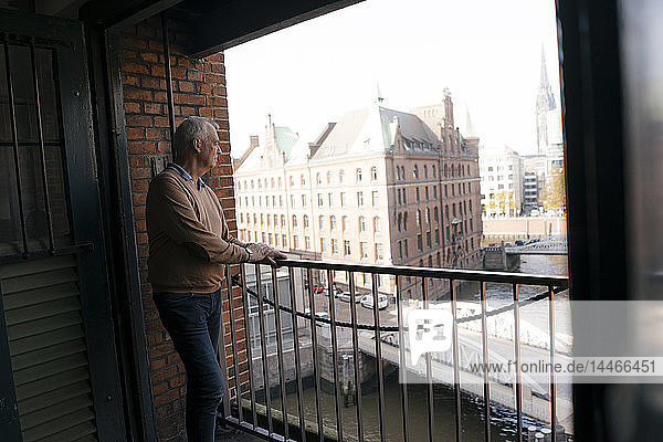 Deutschland  Hamburg  Speicherstadt  leitender Geschäftsmann am Fenster stehend mit Blick über die Stadt