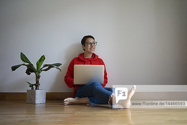 Young woman sitting on floor  using laptop