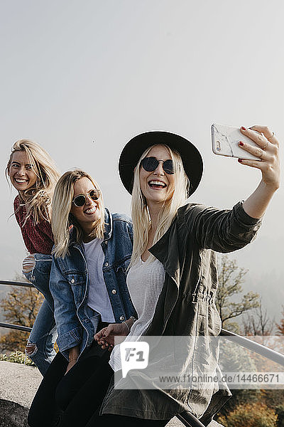 Germany  Black Forest  Sitzenkirch  three happy young women taking a selfie at Sausenburg Castle