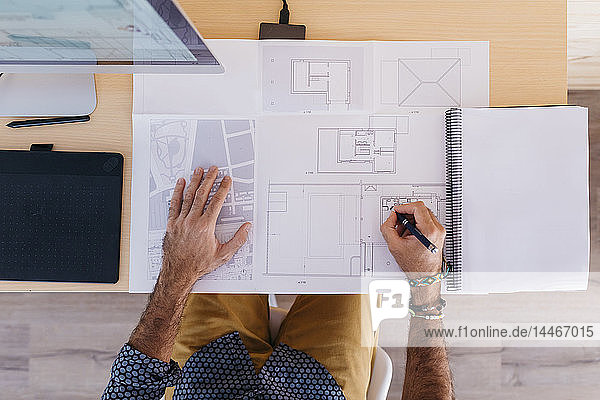 Close-up of architect working at home on floor plan