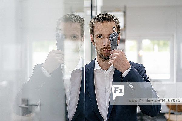Businessman holding his 3D portrait in front of his eye
