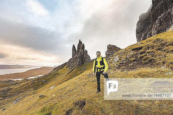 UK  Scotland  Isle of Skye  portrait of smiling man at the The Old Man of Storr on a cloudy day