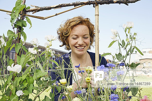 Smiling young woman urban gardening