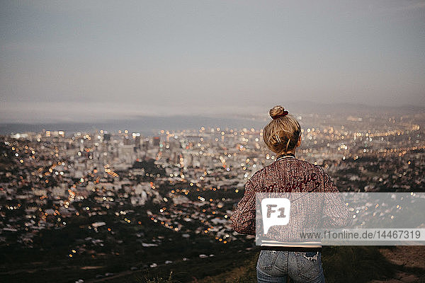 Südafrika  Kapstadt  Kloof Nek  Frau  die das Stadtbild bei Sonnenuntergang betrachtet