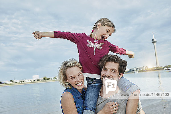 Deutschland  Düsseldorf  glückliche Familie mit Tochter am Rheinufer