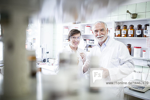Portrait of smiling man and woman in laboratory of a pharmacy