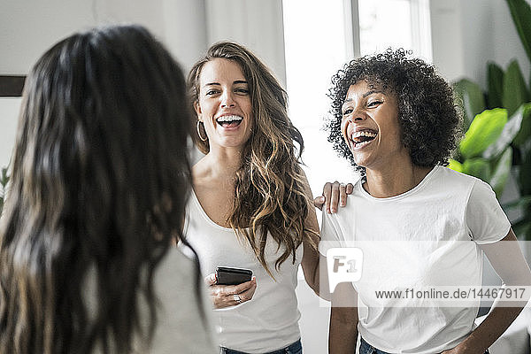 Drei glückliche Frauen  die zu Hause Kontakte knüpfen
