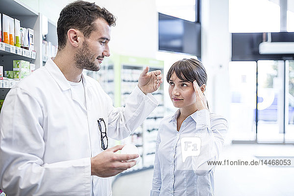 Pharmacist advising customer in pharmacy