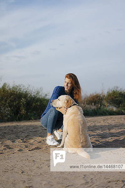 Deutschland  Hamburg  Frau mit Hund am Strand am Elbufer