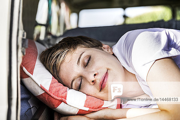 Lächelnde Frau schläft in einem Lieferwagen