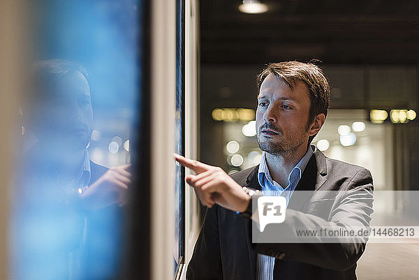 Businessman looking at information panel in the city