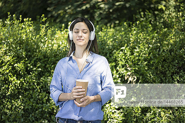 Frau mit Kopfhörern beim Musikhören in der Natur