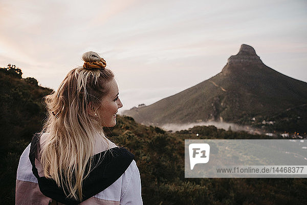 Südafrika  Kapstadt  Kloof Nek  lächelnde Frau auf einer Reise bei Sonnenuntergang