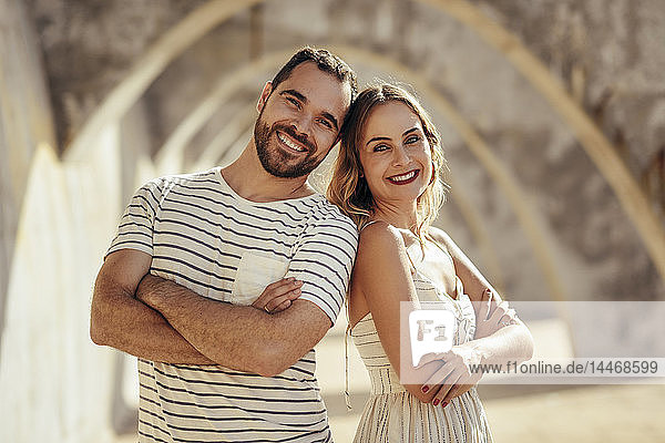 Spanien  Andalusien  Malaga  Porträt eines glücklichen Touristenpaares unter einem Torbogen in der Stadt