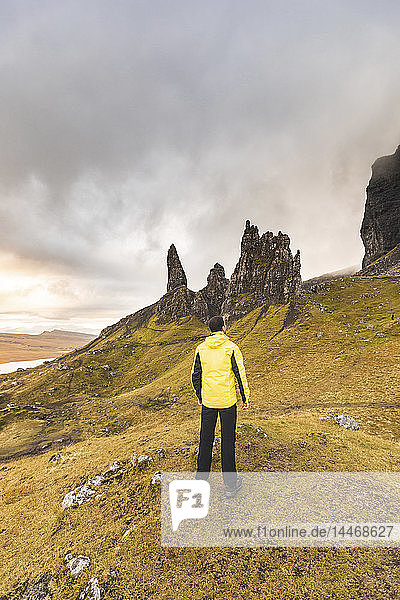 UK  Scotland  Isle of Skye  man hiking to The Old Man of Storr on a cloudy day