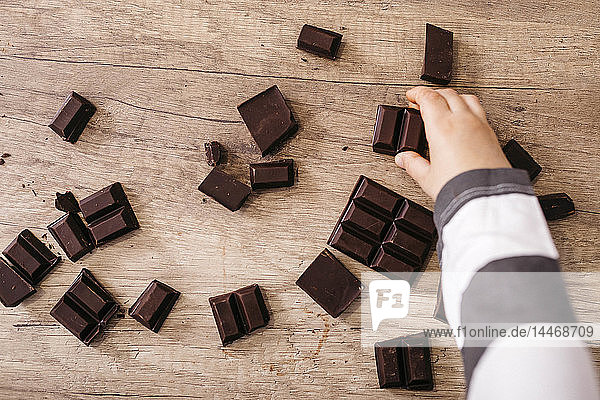 Junge nimmt ein Stück Schokolade in die Hand