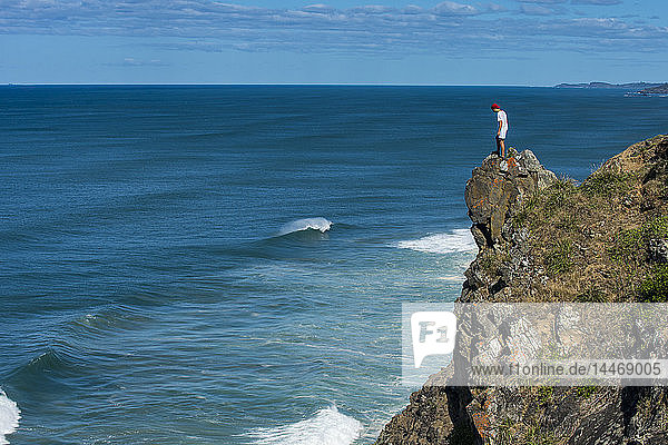 Australien  Queensland  Byron Bay  Mann auf einem Felsen stehend  Klippe bei Cape Byron