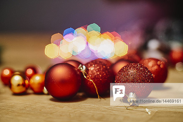 Red Christmas baubles on wooden floor  close-up