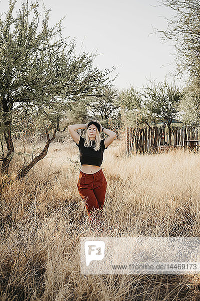 Africa  Namibia  blonde woman standing in grassland