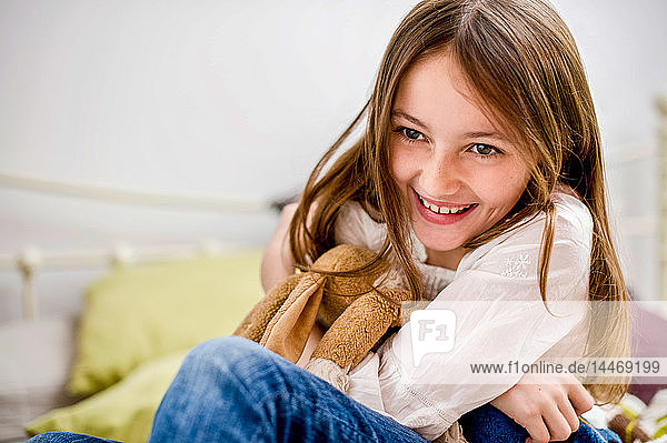 Porträt eines lächelnden Mädchens mit Kuscheltier