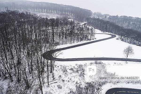 Österreich  Wienerwald  Drohnenschuss einer verschneiten Bergstraße