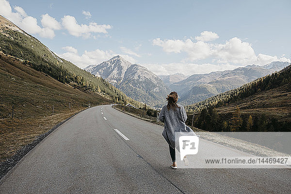 Schweiz  Engadin  Rückansicht einer Frau  die auf einer Bergstrasse geht