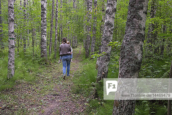 Finnland  Kuopio  Mutter und Tochter spazieren in einem Birkenwald