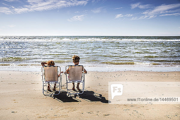 Netherlands  Zandvoort  boy and girl sitting on chairs on the beach