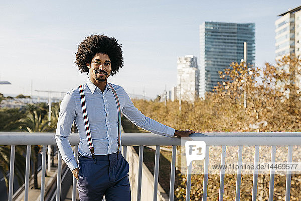 Spanien  Barcelona  Porträt eines lächelnden Mannes  der auf einer Brücke steht