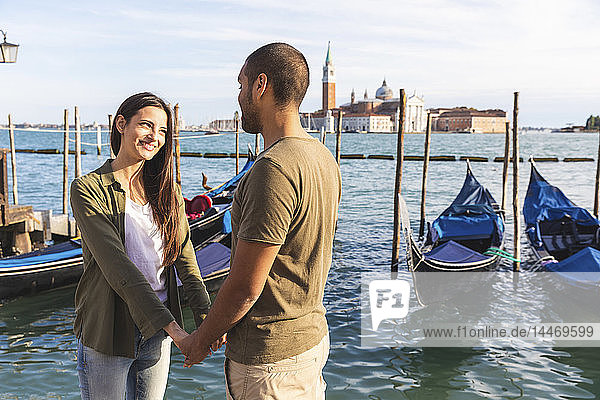 Italien  Venedig  liebevolles junges Paar mit Gondelbooten im Hintergrund