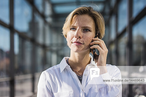 Junge Geschäftsfrau benutzt Mobiltelefon