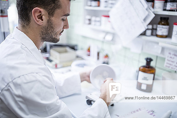 Mann bereitet Medizin im Labor einer Apotheke vor
