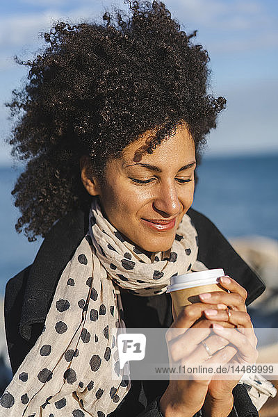 Porträt einer lächelnden Frau  die Kaffee genießt  um ans Meer zu gehen
