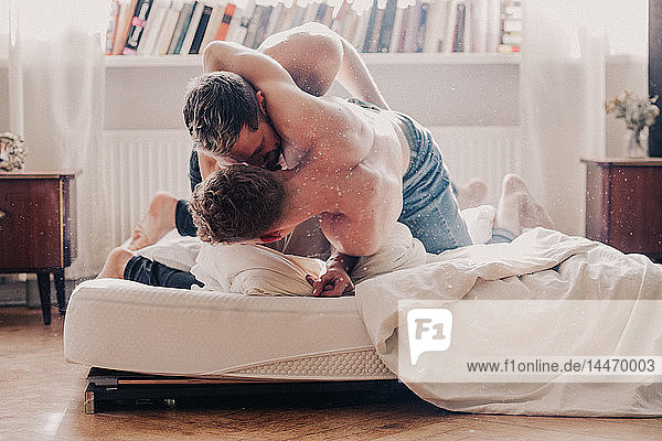 Gay couple fighting in bed