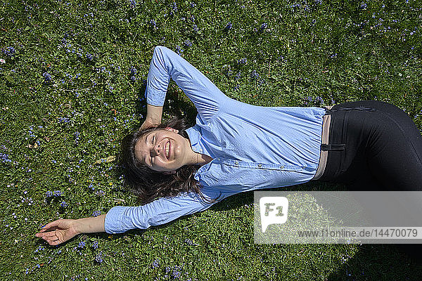 Portrait of happy young woman relaxing on a meadow
