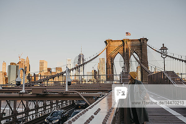 USA  New York  New York City  female tourist on Brooklyn Bridge in the morning light