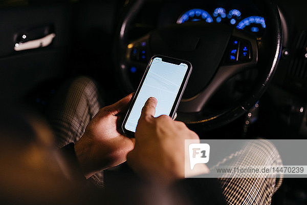 Man using cell phone in the car at night