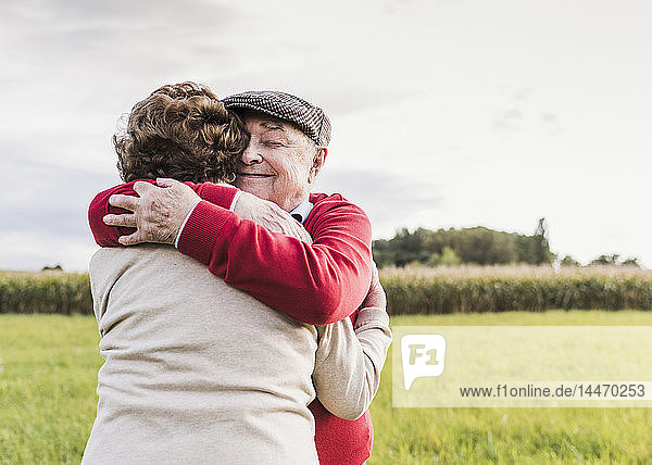 Älteres Ehepaar umarmt sich in ländlicher Landschaft