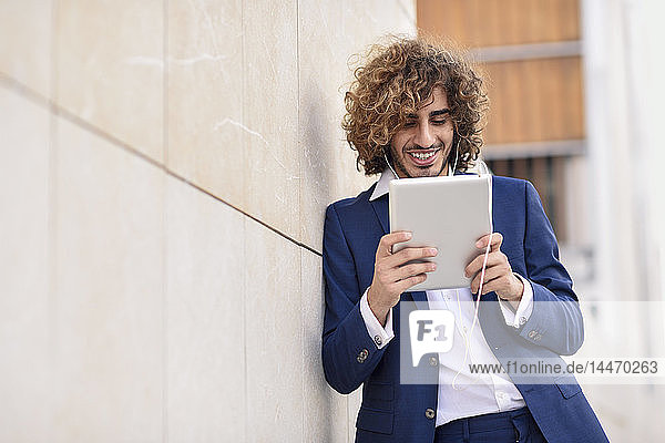 Portrait of young businessman using digital tablet outdoors