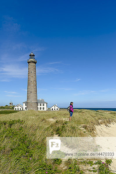 Dänemark Jütland Skagen Grenen Frau steht in den Dünen am grauen Leuchtturm