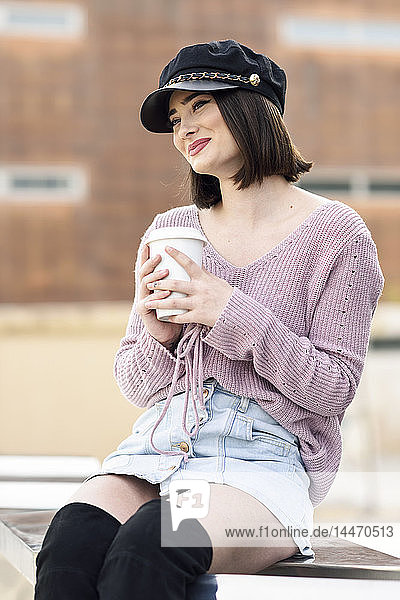 Porträt einer modischen jungen Frau mit Kaffee zum Mitnehmen