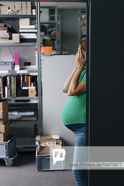 Schwangere Frau versteckt ihr Gesicht im Amt