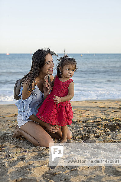 Mother and daughter playing on the beach