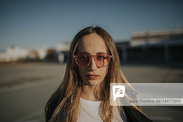 Portrait of young woman wearing sunglasses outdoors