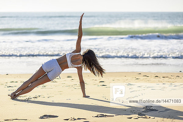 Sportive woman exercising on the beach