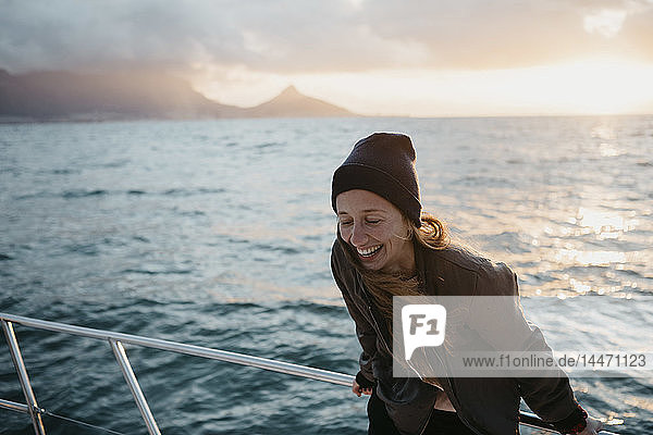 Südafrika  junge Frau mit Wollmütze während einer Bootsfahrt bei Sonnenuntergang