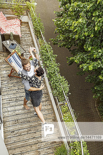 Junges  liebevolles Paar tanzt auf ihrem Balkon